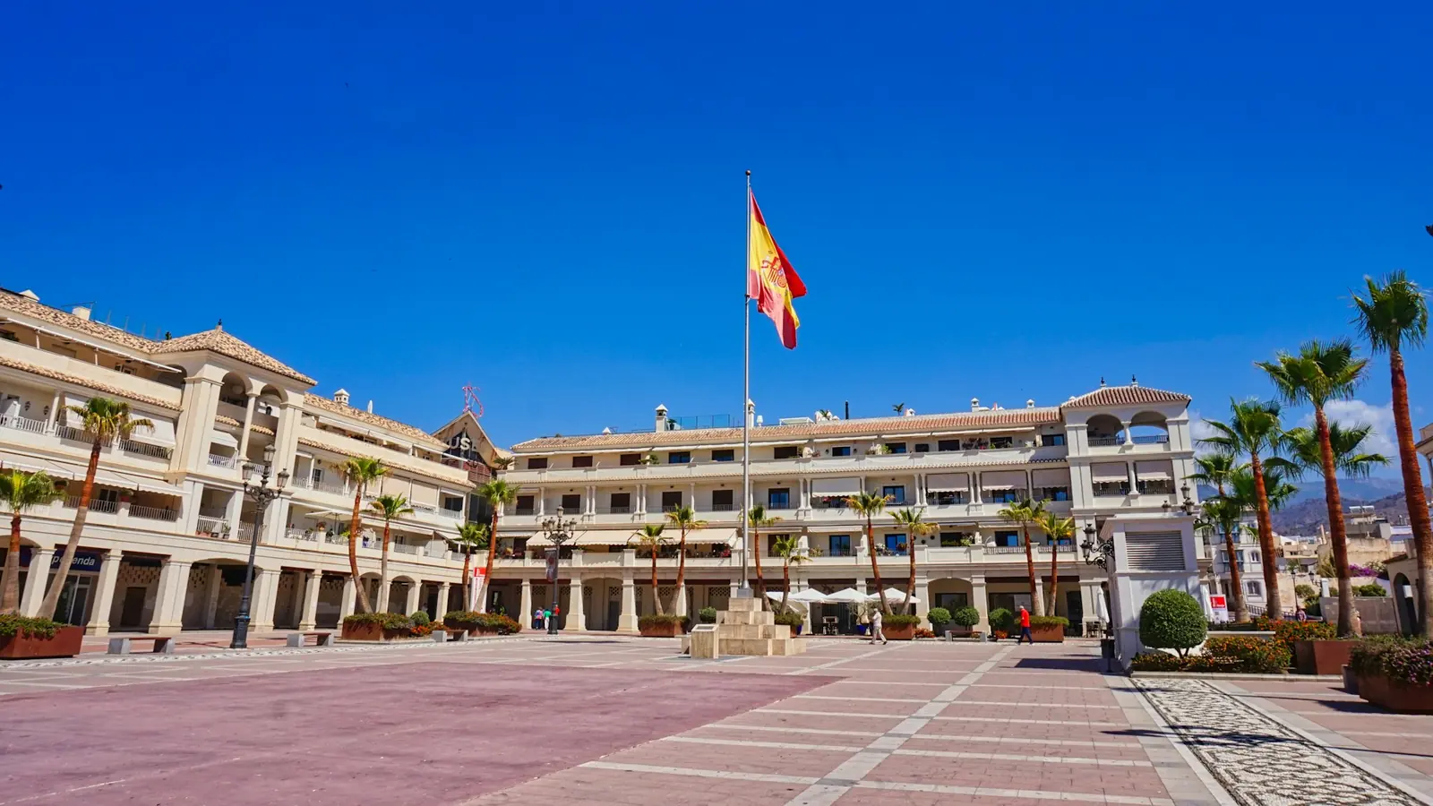 Piazza di Nerja (Málaga, Spagna) con la bandiera spagnola in una giornata di sole