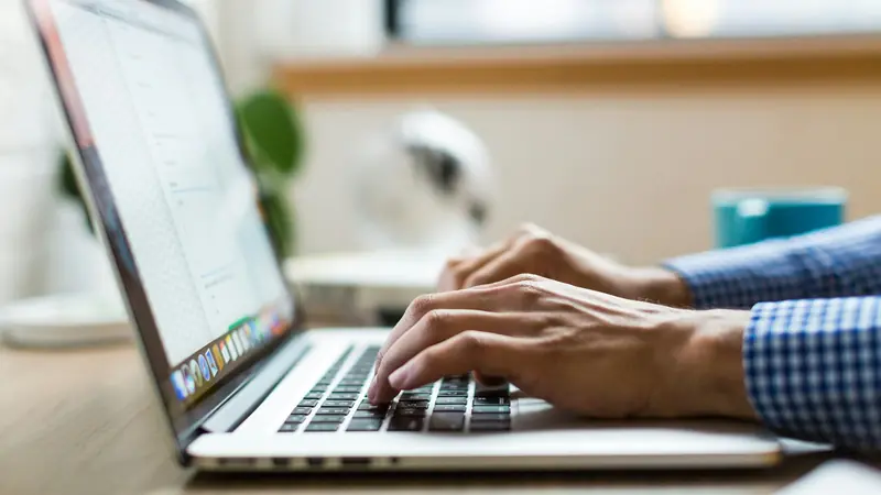 Hände tippen auf einer Laptoptastatur