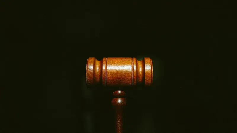 Hölzerner Richterhammer vor dunklem Hintergrund