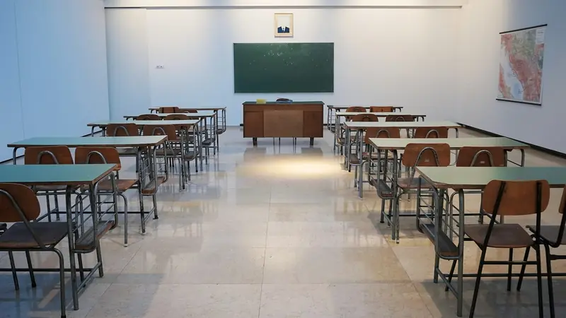 Leeres Klassenzimmer mit Pulten und Tafel